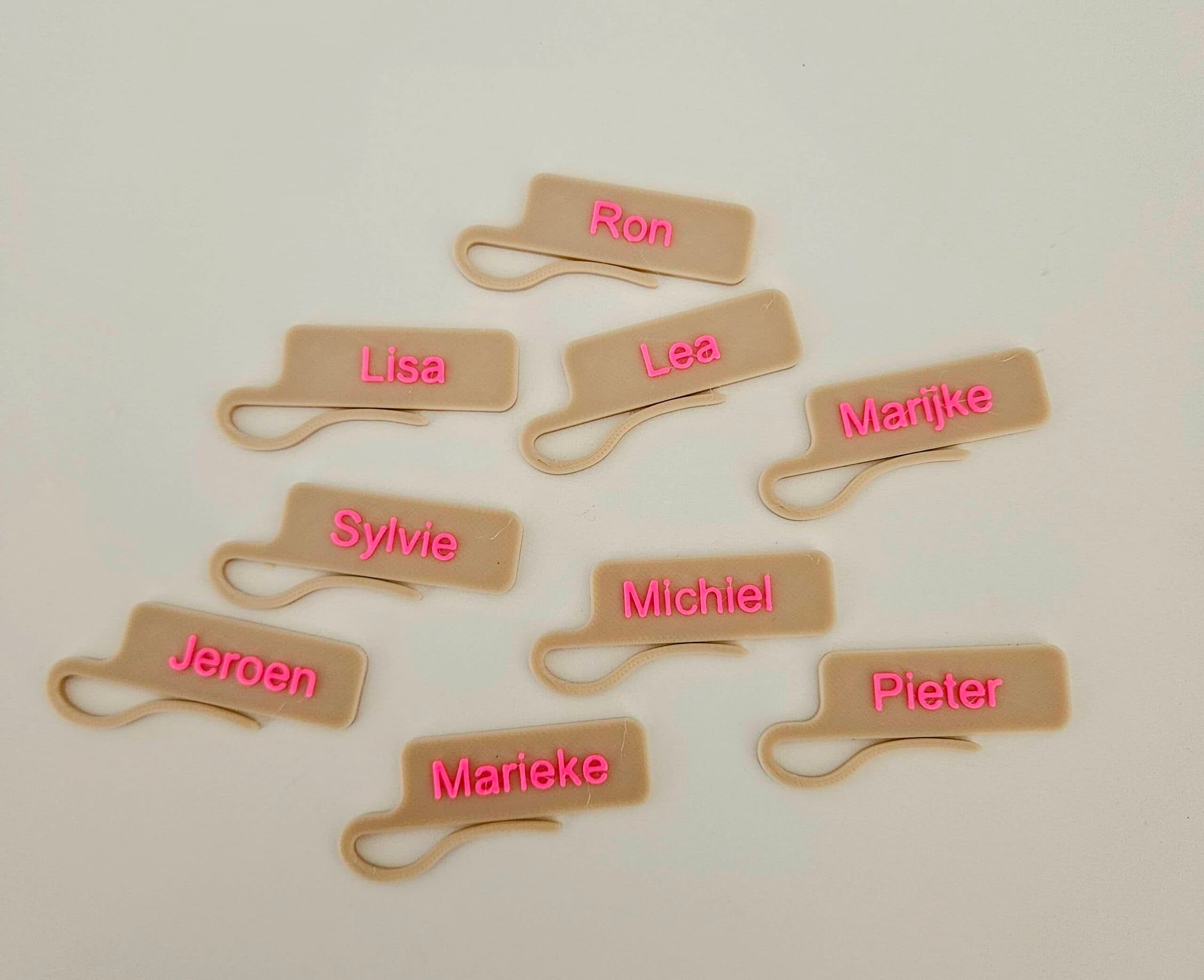 Glasherkenner met naam in neon roze letters op een zandkleurige achtergrond